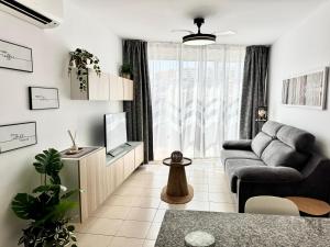 a living room with a couch and a tv at Poseidon Dreams Tenerife in Puerto de Santiago