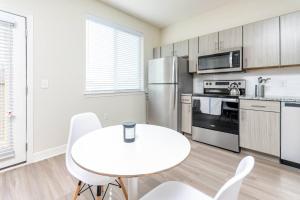 a kitchen with a white table and white chairs at Comfy One BedRoom Apartment in Cedar Park