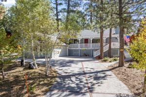 Story Time Hot Tub Game Room EV Charger Back Up Generator Mountain Luxury في بيغ بير لاكي: منزل به ممر يؤدي إلى ساحة بها أشجار