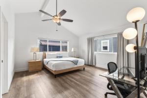 una camera da letto con un letto e un ventilatore a soffitto di Steps to Lido Village and the Marina Heart of Lido Island 2 Car Garage a Newport Beach