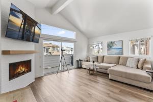 un soggiorno con divano e camino di Steps to Lido Village and the Marina Heart of Lido Island 2 Car Garage a Newport Beach