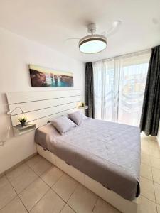 a bedroom with a bed and a large window at Poseidon Dreams Tenerife in Puerto de Santiago