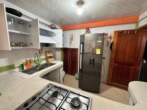 a kitchen with a refrigerator and a stove in it at Quimbaya Private House in Quimbaya