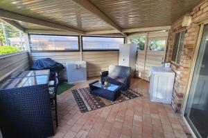 a screened in porch with a chair and a table at Cosy Bayside Studio in Esperance