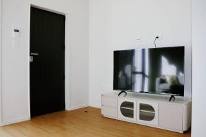 una TV a schermo piatto seduta sopra un armadio bianco di Cozy 2 Bedroom Waterview Home for Work and Family ad Auckland