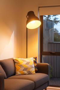un soggiorno con divano, lampada e finestra di Cozy 2 Bedroom Waterview Home for Work and Family ad Auckland