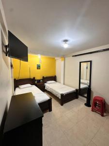 a room with two beds and a mirror at Quimbaya Private House in Quimbaya