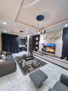 uma sala de estar com um sofá e uma TV de tela plana em 1 Bedroom Apt Sabolak Suite Sapphire em Ikate