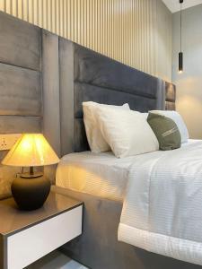 um quarto com uma cama com uma cabeceira e um candeeiro em 1 Bedroom Apt Sabolak Suite Sapphire em Ikate mais 37 fotografias