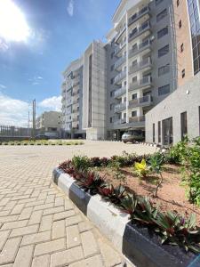 um pátio com plantas em frente a um prédio em 1 Bedroom Apt Sabolak Suite Sapphire em Ikate