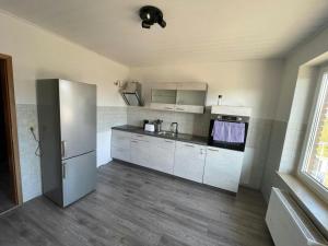 a kitchen with white cabinets and a refrigerator at Spacious Apartment for 6 in Bobitz