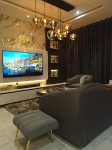 a living room with a couch and a tv at 1 Bedroom Apt Sabolak Suite Haven in Ikate