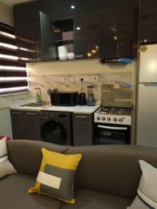 a living room with a couch and a kitchen at 1 Bedroom Apt Sabolak Suite Haven in Ikate