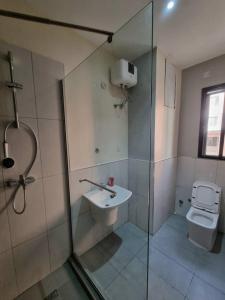a bathroom with a shower and a sink and a toilet at 1 Bedroom Apt Sabolak Suite Haven in Ikate +24 photos