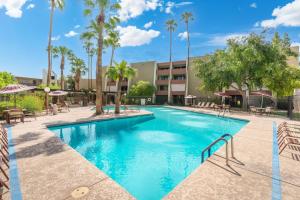 a swimming pool at a resort with palm trees at Walk to Old Town - 1BR Condo, Heated Pool and Patio in Scottsdale