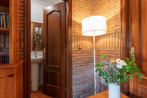 Cette chambre comprend une table avec une lampe et un mur en briques. dans l'établissement Casa Rural La Venta, à Iruz 37 autres photos