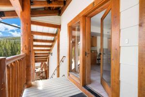 an open door to a balcony with a view of the mountains at St Marys Glacier Getaway in Ninetyfour