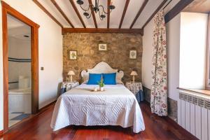 une chambre avec un lit et un mur en pierre dans l'établissement Casa Rural La Venta, à Iruz