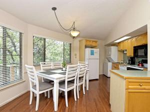 a kitchen and dining room with a table and chairs at Lakefront Bungalow With Community Poolhot Tub #5 in Lakeway +1 photo
