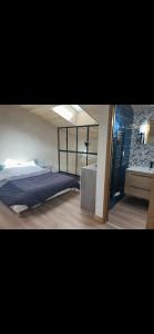 a bedroom with a large bed and a bathroom at Le gîte de capucine in Saint Loup Lamaire
