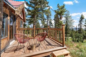 a deck with two chairs on a house at The Tyrolean Cabin. Panoramic Views. Hot Tub. in Wondervu