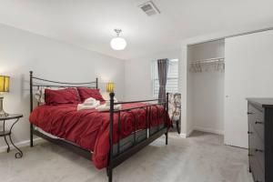 a bedroom with a bed with a red comforter at The New Cherry Creek Retreat. 4BR. Large Back Yard in Glendale