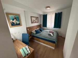 a small bedroom with a bed and a window at Glio Luxury Apartment in Skopje