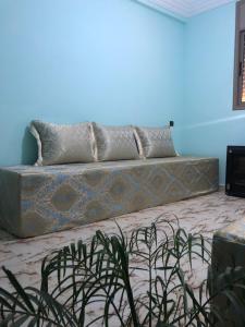 a couch in a room with a blue wall at Dar Fatima in Tamensourt