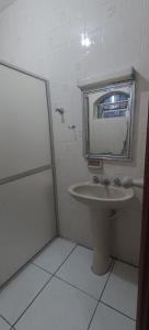 a bathroom with a sink and a mirror at Tia do Coco Recanto in Caraguatatuba +13 photos