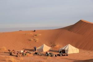 a group of people and tents in the desert at Casa de las Estrellas in Mhamid +13 photos