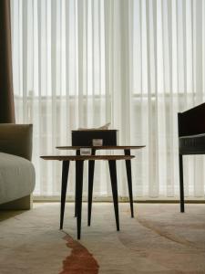 a table in a living room with a couch and a window at Elios Living Studio Mettewie in Brussels
