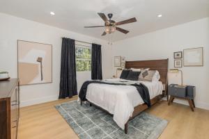 a bedroom with a bed and a ceiling fan at Modern Village Hideaway - Curly2 in Melbourne Village