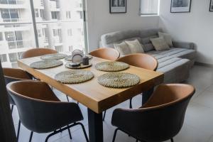 a dining room table with chairs and a couch at New modern apartment in Barranquilla