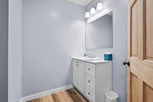 Un baño blanco con lavabo y espejo. en Sweet Solitude On Main, en Warrensburg 9 fotos más