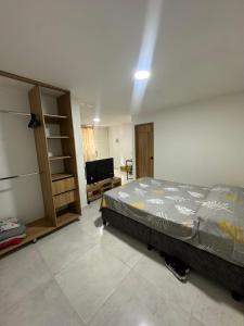 サン・ヒルにあるApartamento Playa Realのベッドとテレビのある寝室 +2枚の写真
