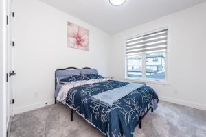 a bedroom with a bed and a window at Luxury Home Near DT, New Build, High-End Features in Calgary