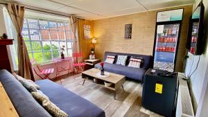 a living room with a blue couch and a soda machine at Patagon Backpackers in Coihaique