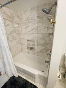 サラトガ・スプリングズにあるBright 2 Bedroom Home Close To The Trackのシャワー付きの浴室の浴槽