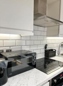 eine Küche mit einer Arbeitsplatte und einer schwarzen Mikrowelle in der Unterkunft 1 Bed Central Leeds Luxury Stay in Leeds