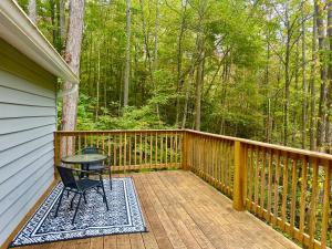 a wooden deck with a table and a chair on it at Beary Cozy in Fairview