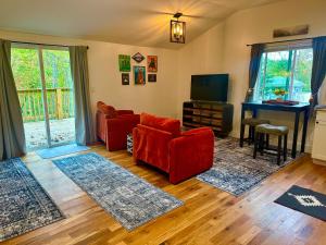a living room with red chairs and a television at Beary Cozy in Fairview