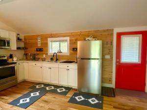 a kitchen with a refrigerator and a red door at Beary Cozy in Fairview