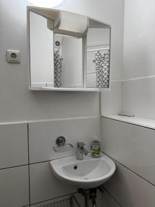 a white bathroom with a sink and a mirror at Frankenthal in Bobenheim-Roxheim