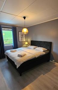 a bedroom with a large bed with two towels on it at Nordic villa with outdoor jacuzzi and Aurora Borealis view 