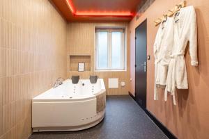 a bathroom with a bath tub and a sink at Japan Universe Spa & Arcade in Mulhouse