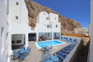 a villa with a swimming pool and blue chairs at Dodomar Selections in Perissa