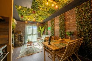a room with a table and chairs and a ceiling with plants at La Jungle Evasion, séjour immersif en famille in Hennebont