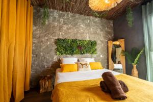 a bedroom with a large bed with a yellow blanket at La Jungle Evasion, séjour immersif en famille in Hennebont