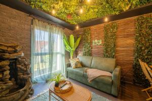 a living room with a couch and a brick wall at La Jungle Evasion, séjour immersif en famille in Hennebont