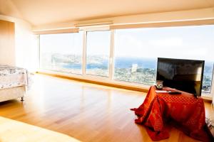 a room with a bed and a television with large windows at Viva B&B in Anavyssos